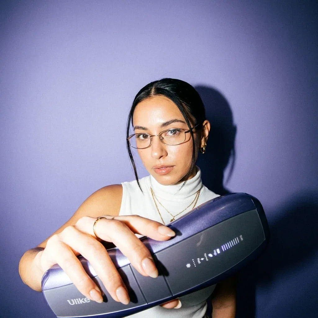 Woman in glasses holding the Ulike Air 10 out toward the camera